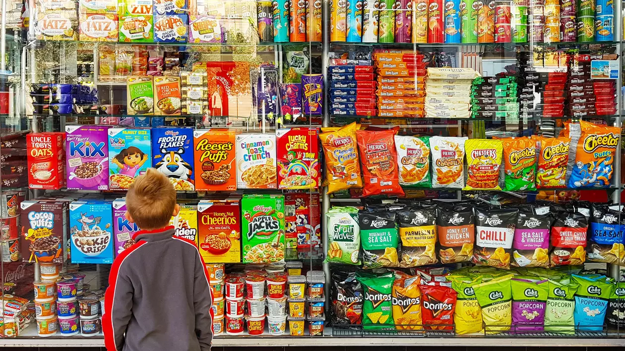 Copil în fața raftului cu dulciuri dintr-un supermarket Foto Shutterstock