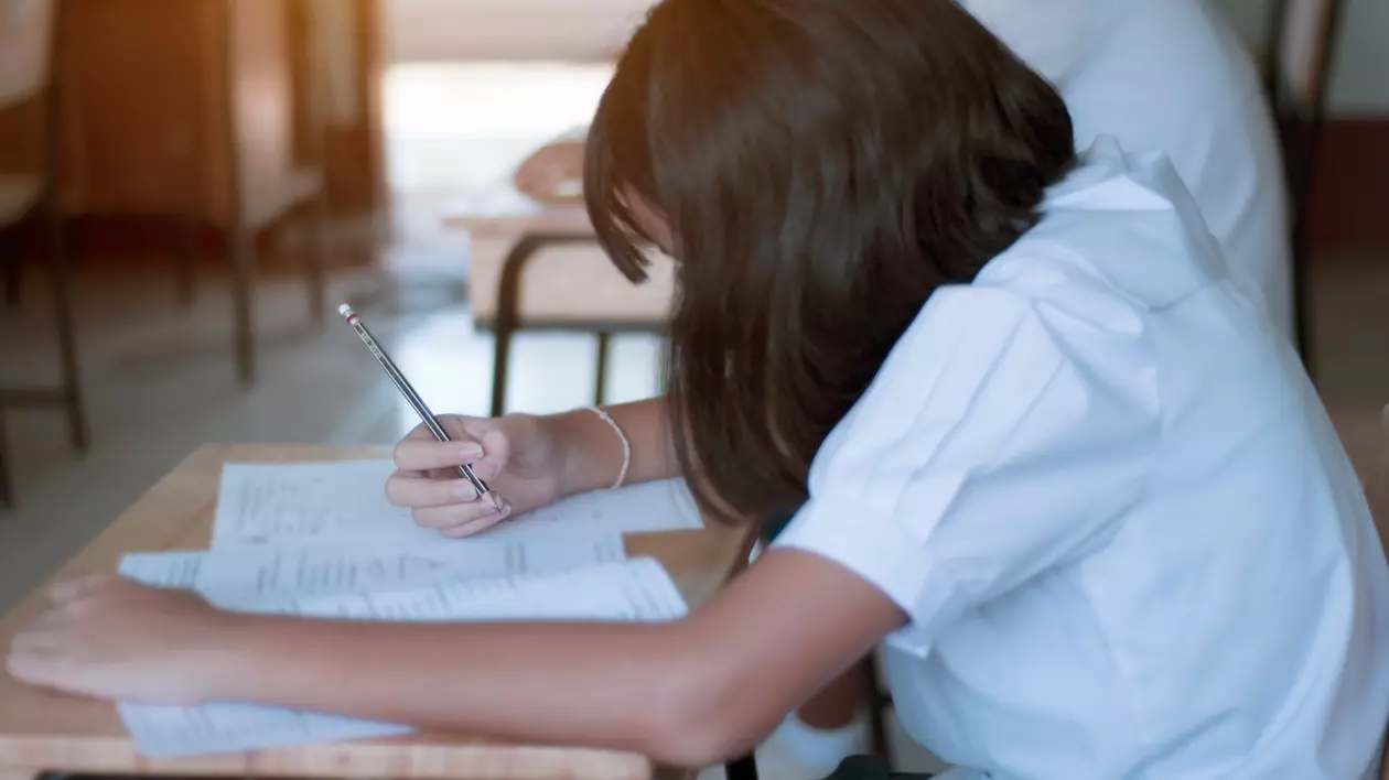 Rezultate Evaluare Națională 2024 - Imagine cu o elevă de gimnaziu care dă un examen