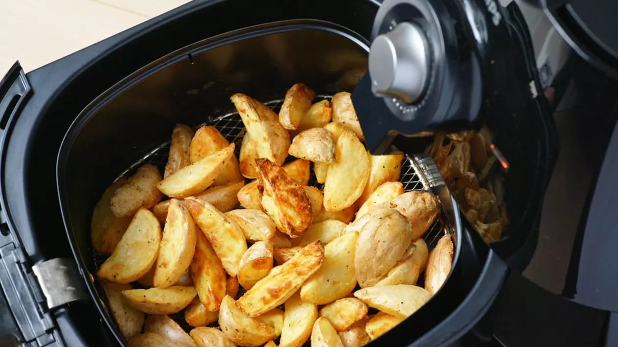 Cât de sănătoase sunt alimentele gătite la friteuza cu aer cald - Imagine cu cartofi prăjiţi în sertarul unui air fryer.