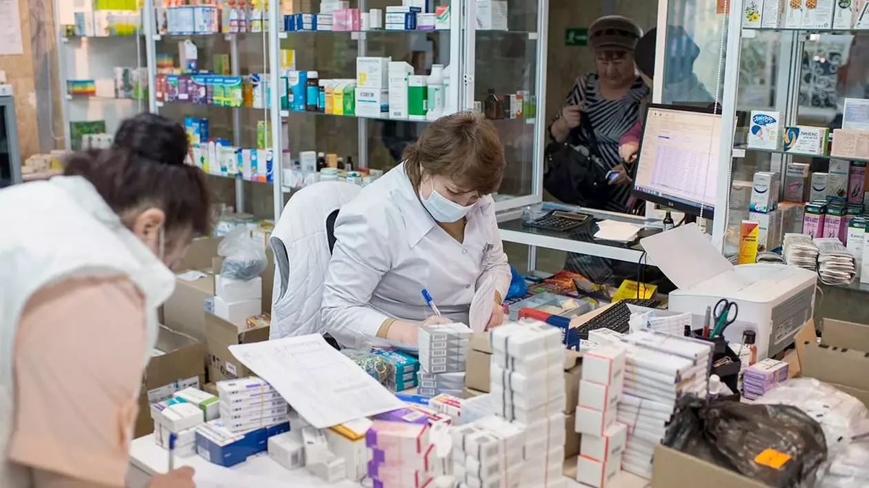 Mai multe farmaciste și cutii cu medicamente, într-o farmacie.