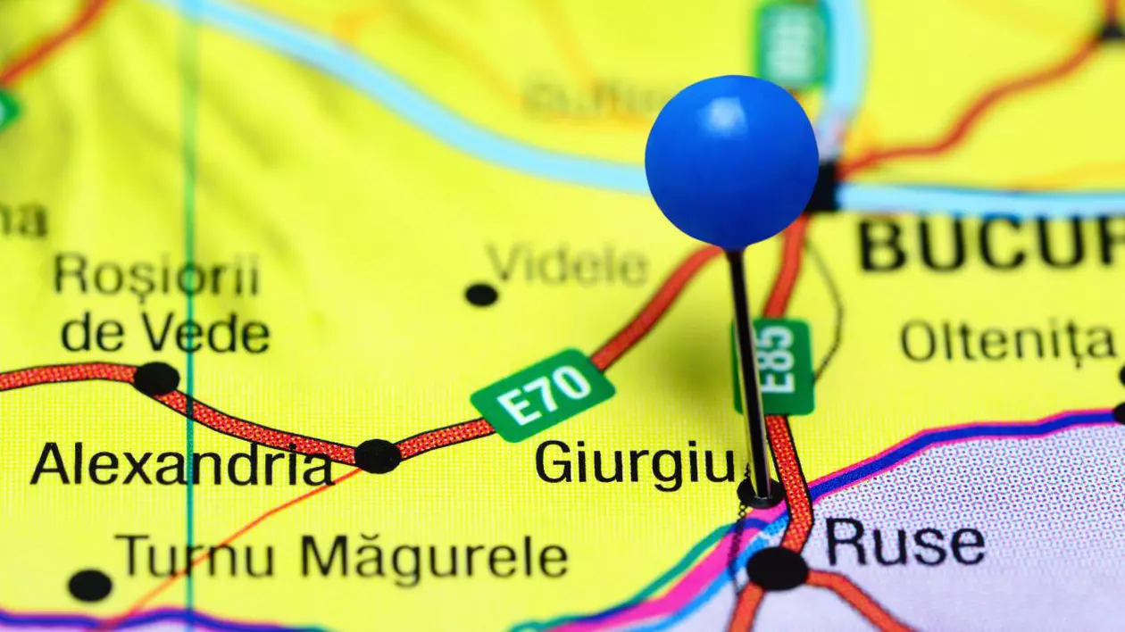 Harta României, pe fundal galben, cu un pin albastru pus pe Giurgiu