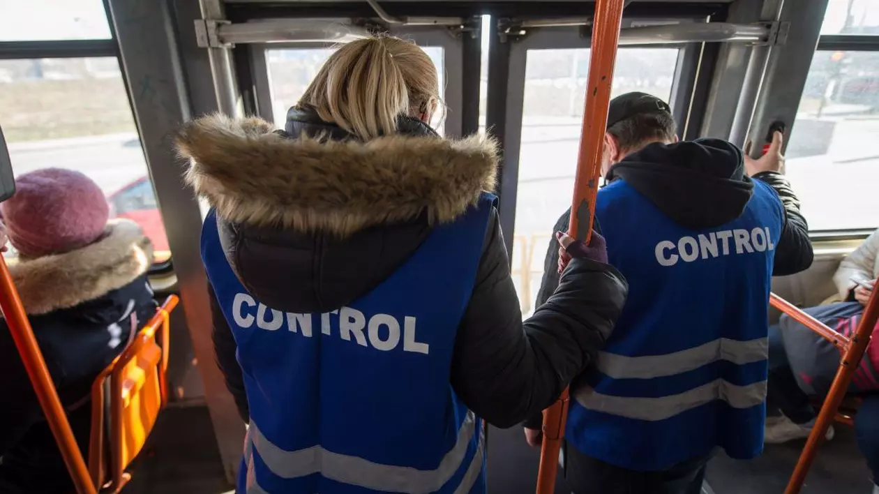 Doi angajați ai serviciului de transport coboară din tramvai după ce au verificat călătorii