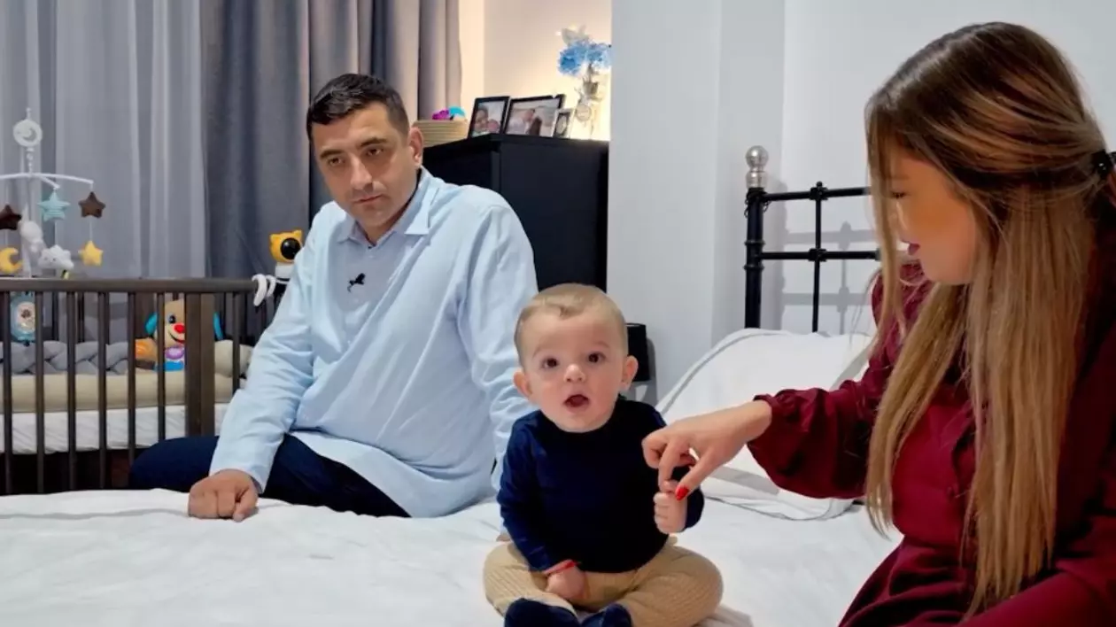 George Simion, îmbrăcat cu o cămașă, în timp ce stă pe pat, alături de fiul său, Radu, și de soția sa, Ilinca, îmbrăcată într-o rochie roșie