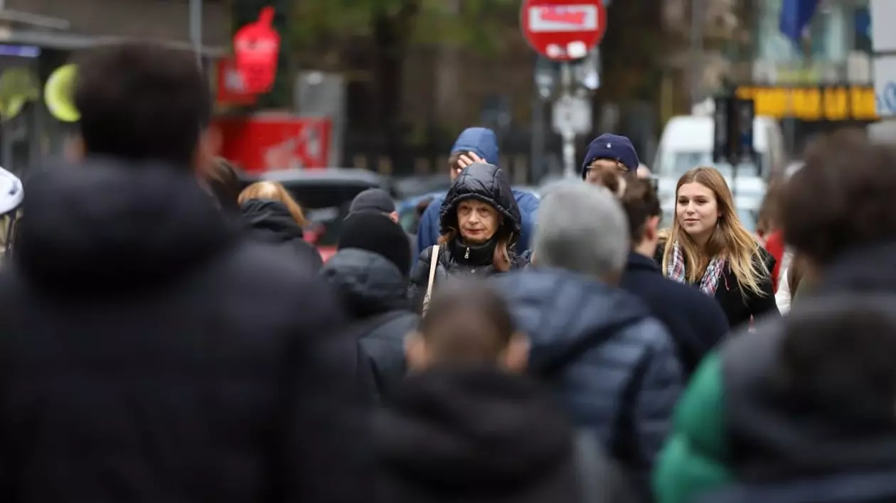 Mai mulți oameni gros îmbrăcați și cu capul acoperit traversează strada, în București. Foto cu caracter ilustrativ: Libertatea/Dumitru Angelescu