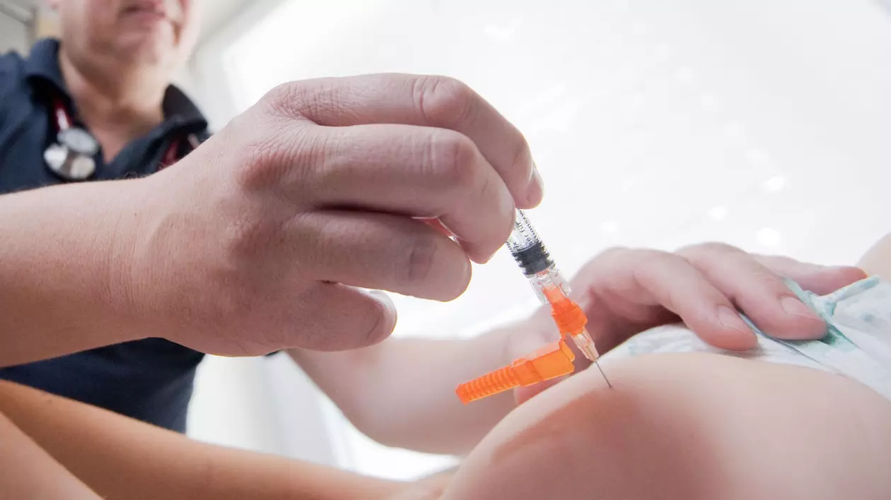 Un doctor vaccinează un copil