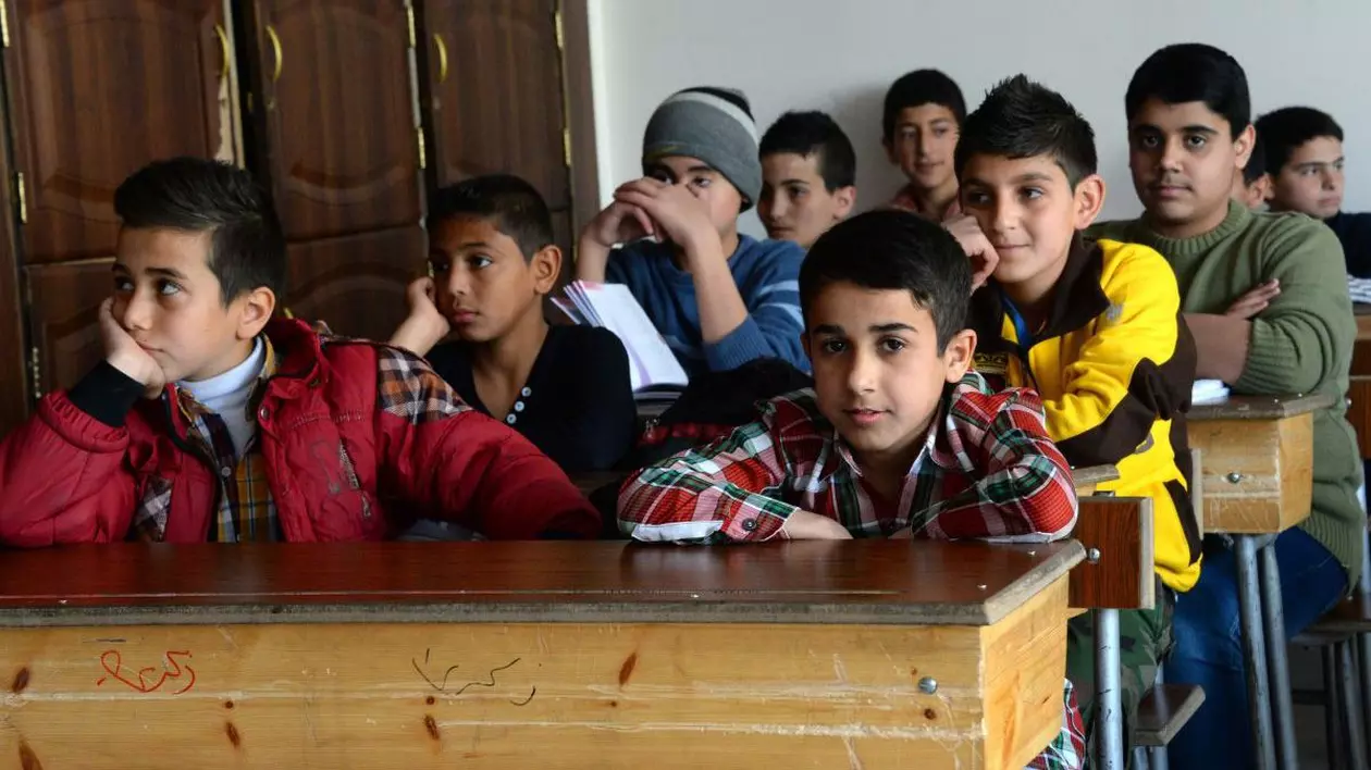 Elevi din Siria care asistă la o lecție, în școală