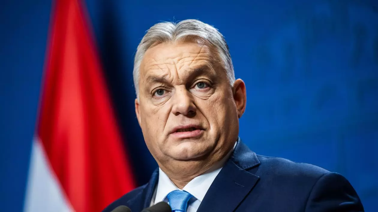 Premierul maghiar Viktor Orban, în timpul unei conferințe de presă, vorbind la microfon, îmbrăcat într-un sacou bleu-marin cu o cravata bleu și o cămașă albă