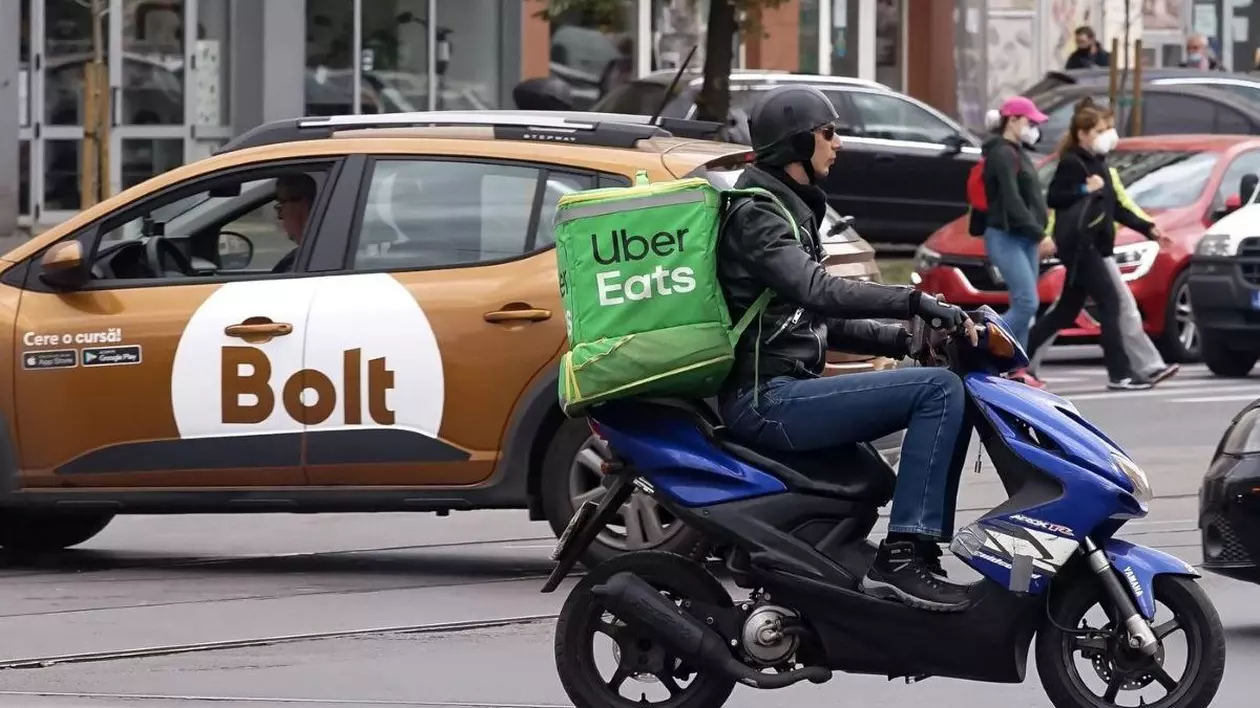 Un șofer Bolt cu o mașină maro și un livrator Uber, la muncă pe străzile din România