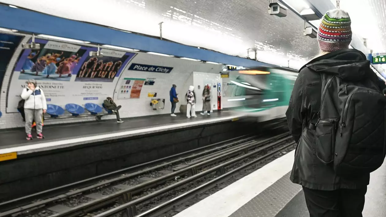 Un tren de metro sosește într-o stație și pe peron sunt mai mulți călători