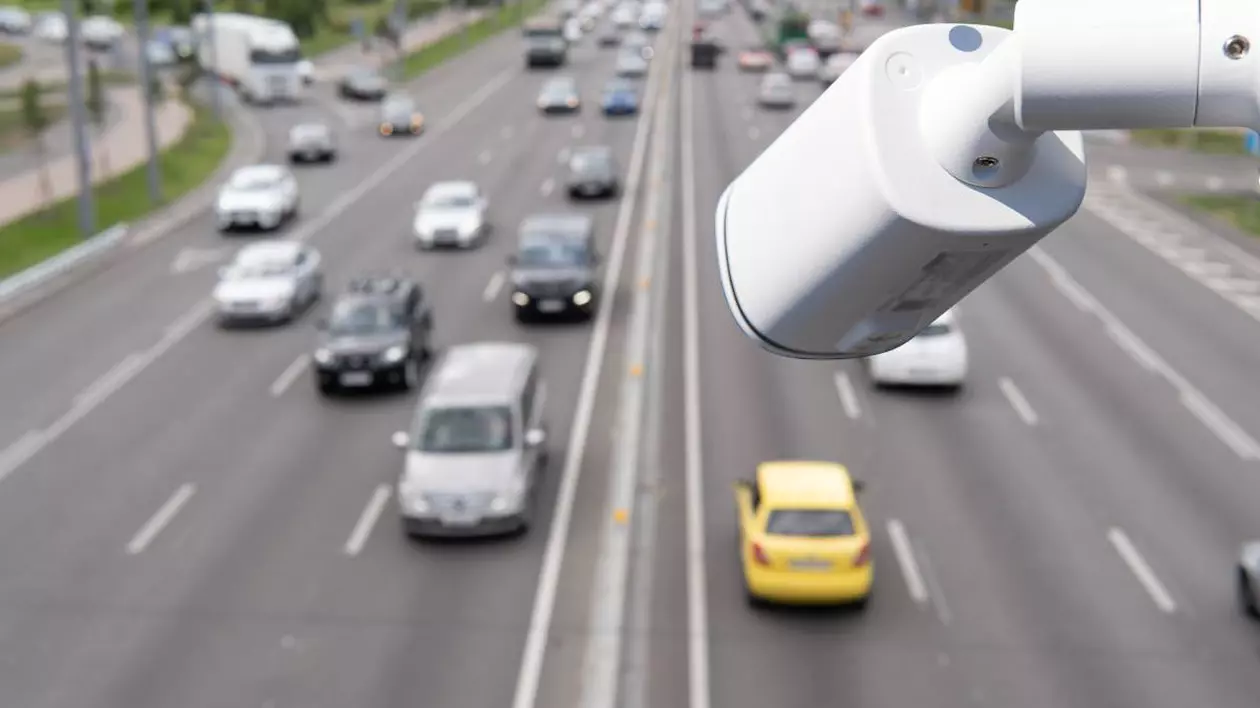 camera de supraveghere trafic alba. pe fundal mai multe masini in trafic