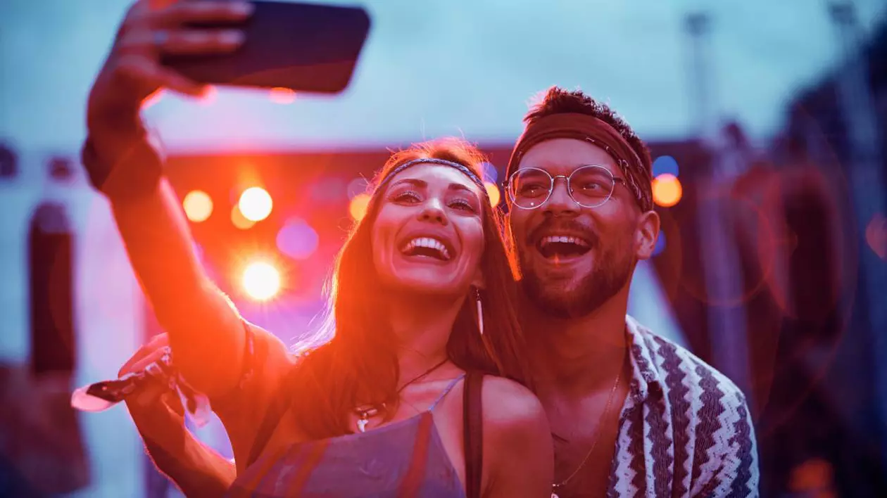fotografie cu un cuplu care isi fac un selfie imbracati in haine de festival