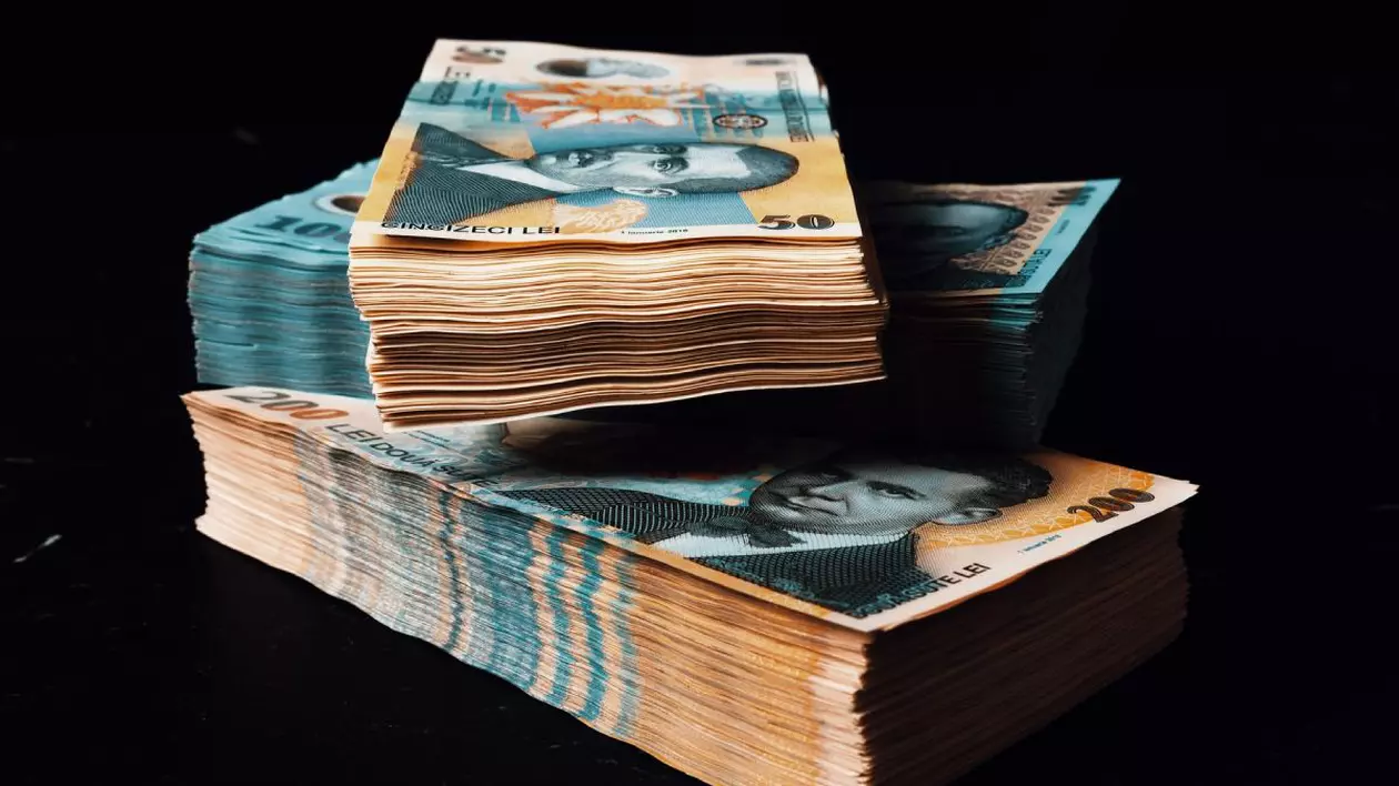 Trei teancuri de bancnote de 100 și 200 de lei pe fundal negru