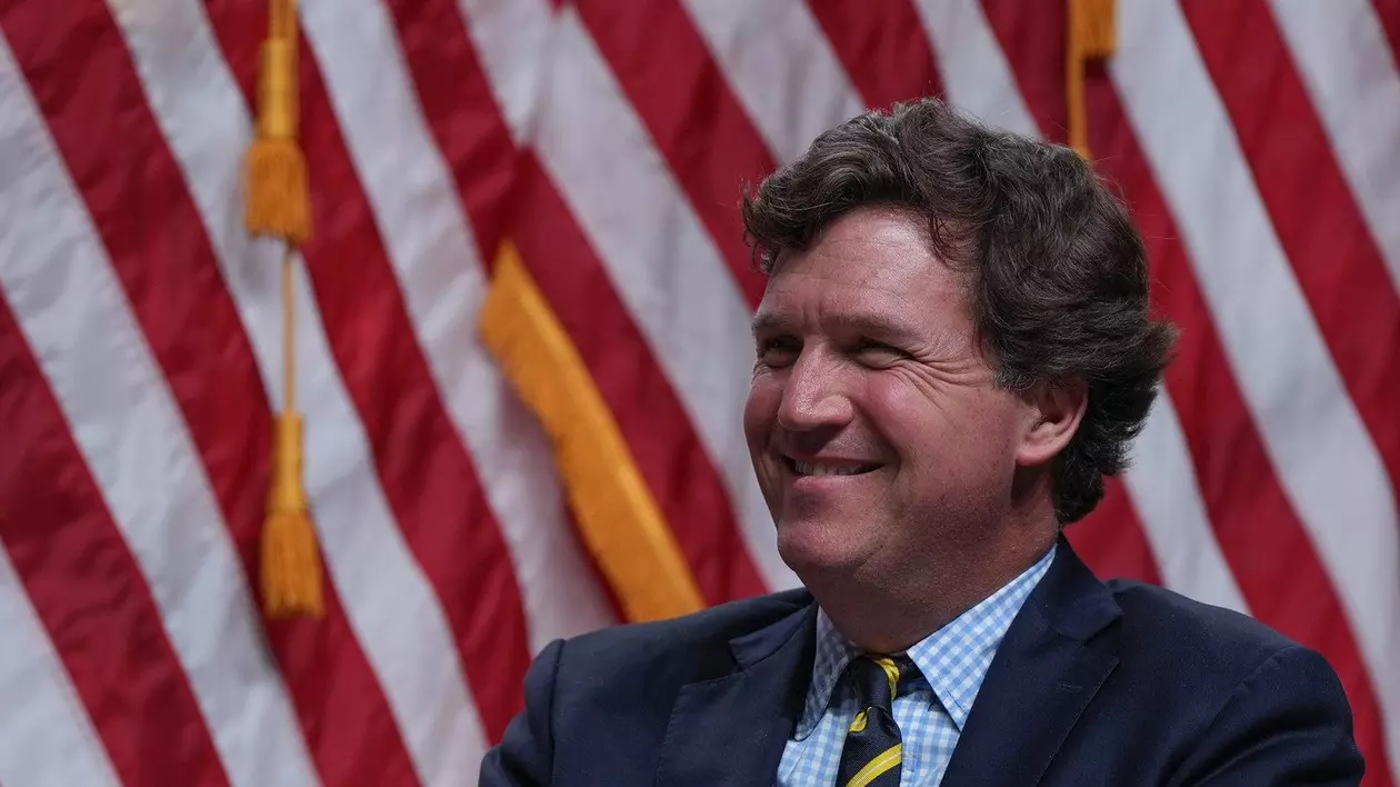 Tucker Carlson ascultă în timp ce candidatul republican la președinție, fostul președinte Donald Trump, vorbește în timpul unui spectacol Tucker Carlson Live Tour la Desert Diamond Arena, joi, 31 octombrie 2024, în Glendale, Arizona.