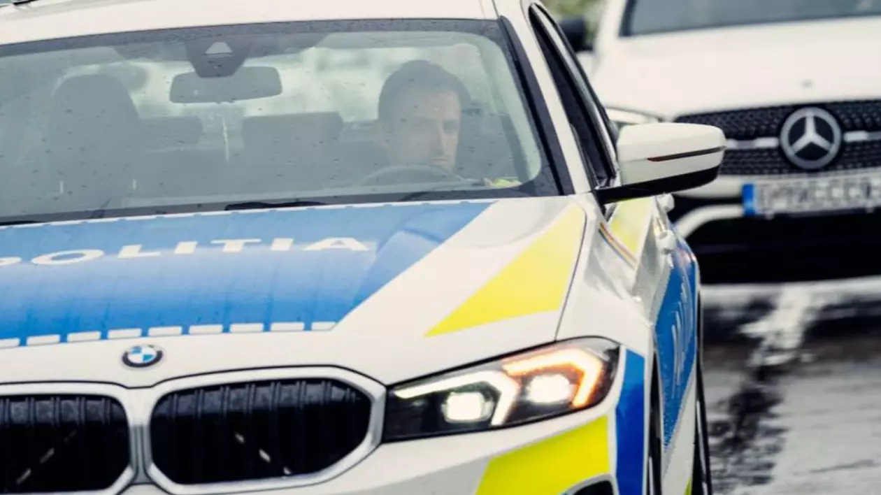 Un BMW al Poliției Rutiere, în prim plan, inscripționat oficial, și în plan secund un Mercedes de culoare albă