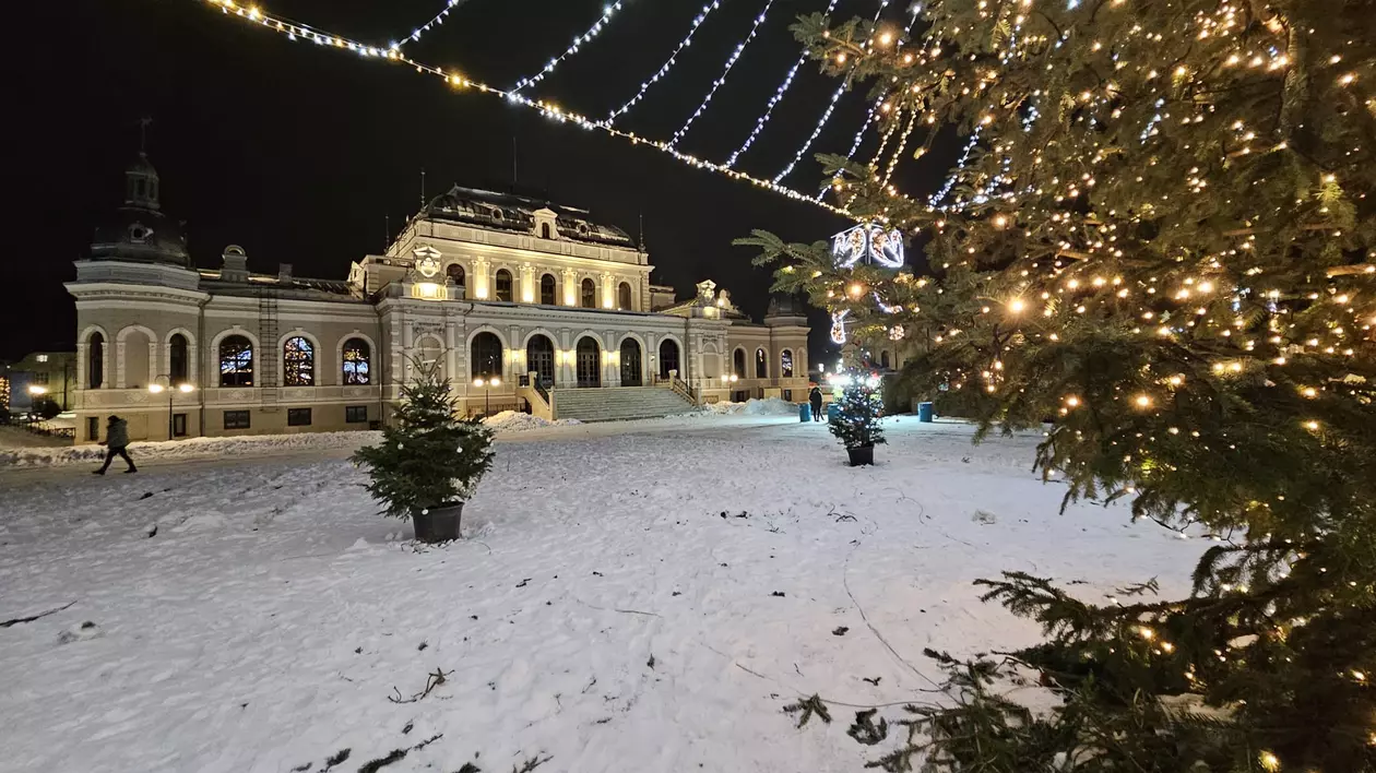 Imagine ilustrativă din Vatra Dornei, cu o stradă acoperită de zăpadă, luminițe de Crăciun și un brad împodobit