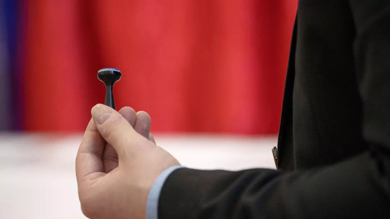 Un bărbat ține în mână o ștampilă de vot, în primul tur al alegerilor prezidențiale din 2024