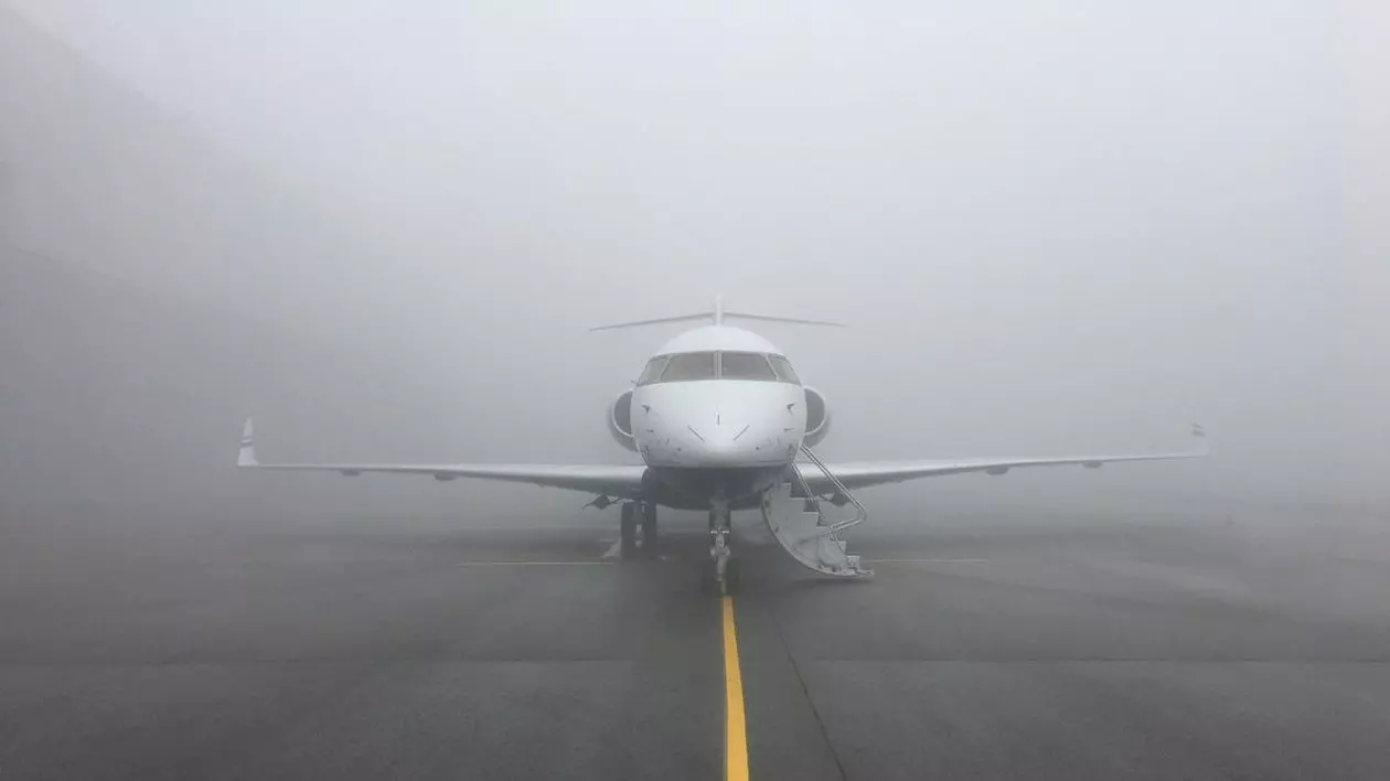 avion pe pista de decolare, înconjurat de ceață densă