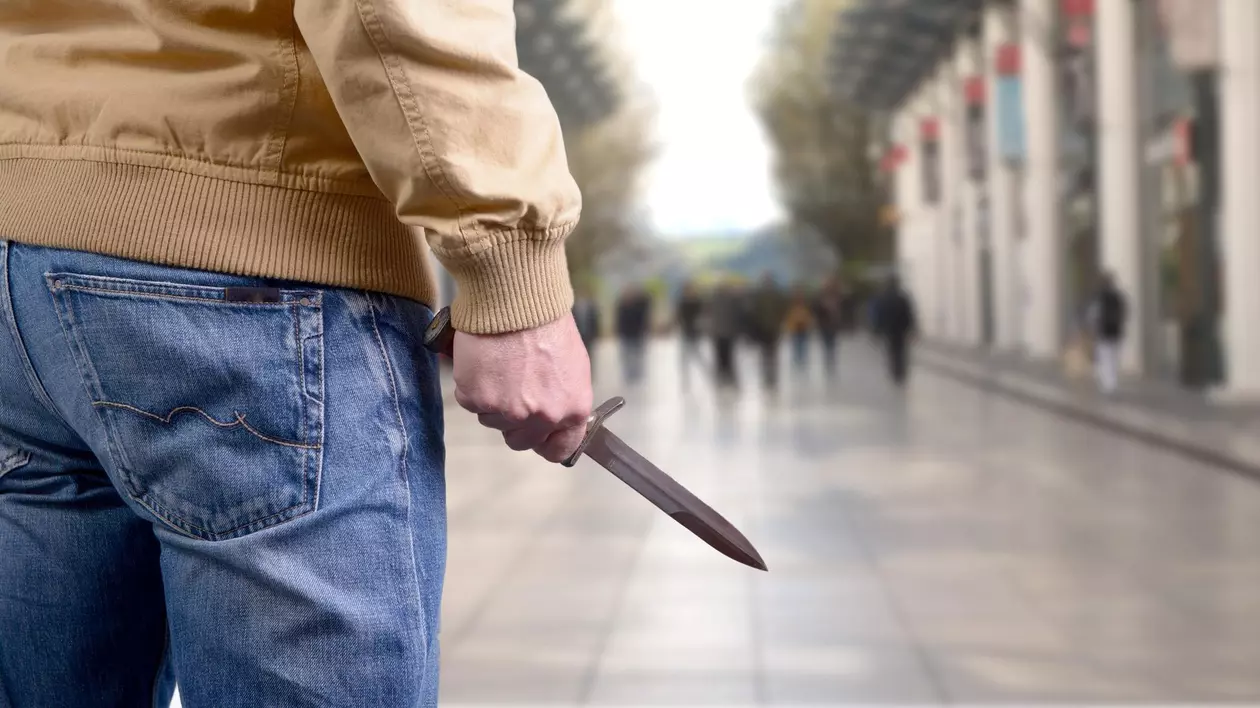 Bărbat care ține în mână un cuțit.