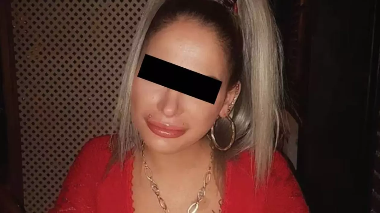 femeie blonda cu o bluza rosie, in partea ochilor este o banda neagra