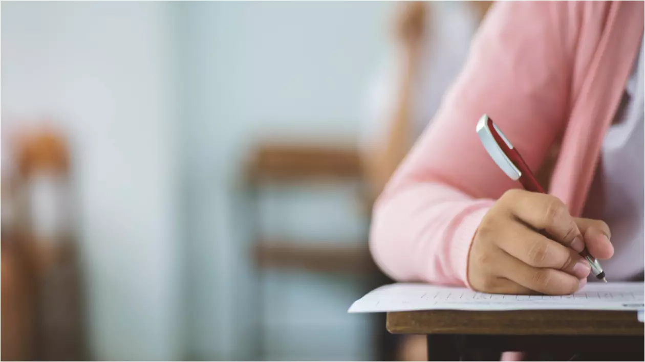 O elevă în timpul unui examen, cu un pix în mână