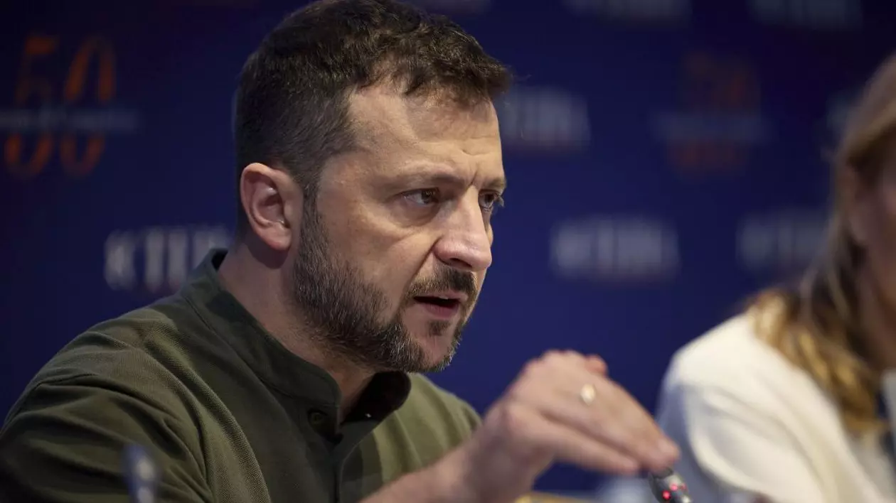 Președintele Ucrainei, Volodimir Zelenski, dă din mână și explică ceva