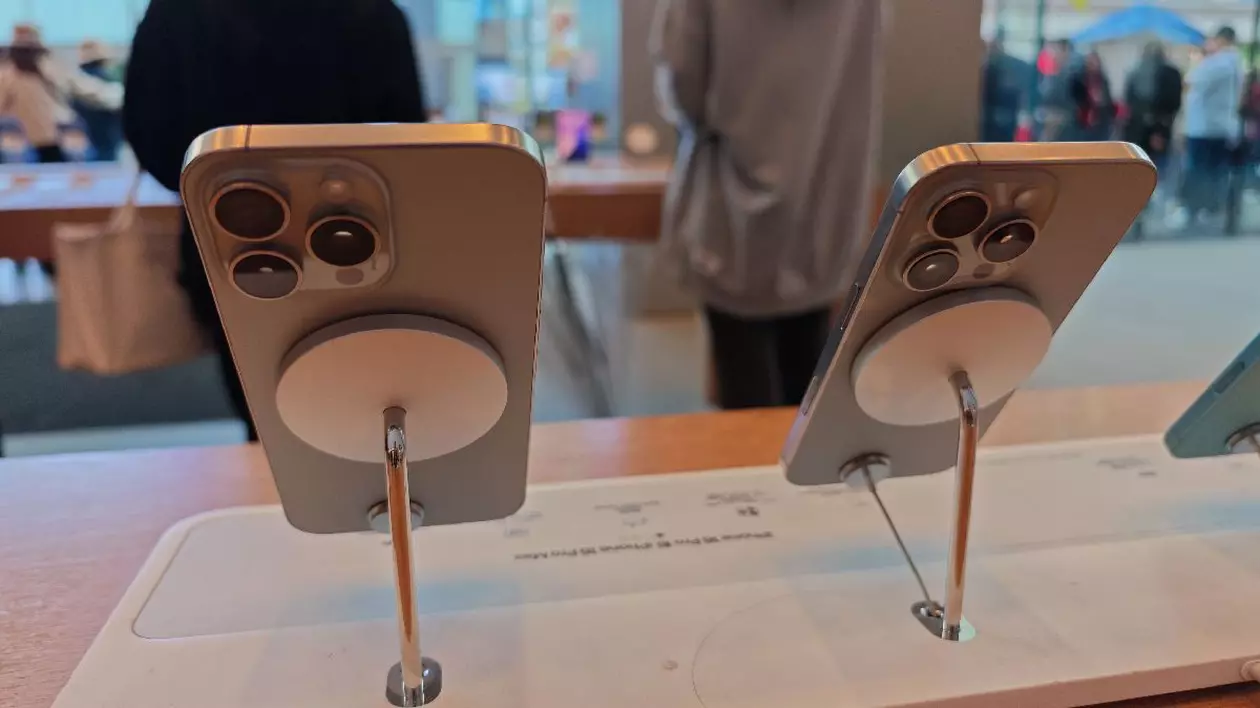 Două telefoane gri din seria iPhone 16 sunt așezate pe standuri de prezentare într-un magazin Apple din Shanghai, China.