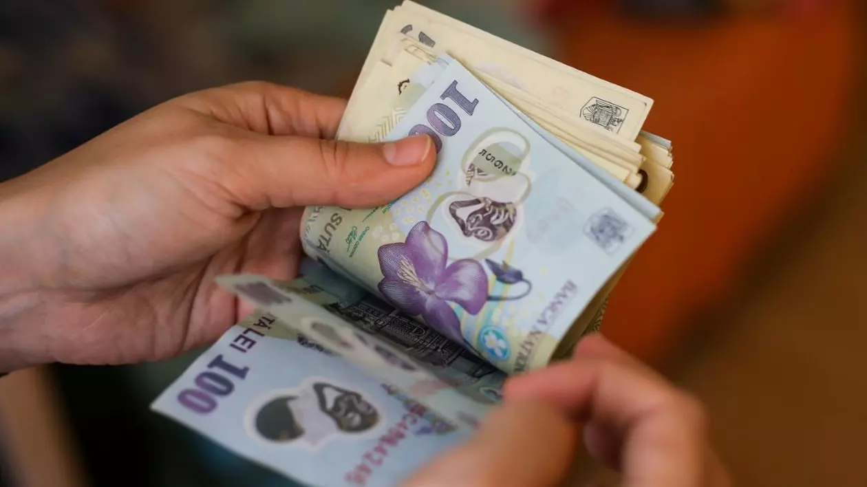 O domnișoară numără bancnote de 50 și 100 de lei românești