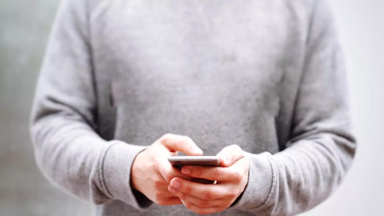 Bărbat care ține în mâini un telefon mobil
