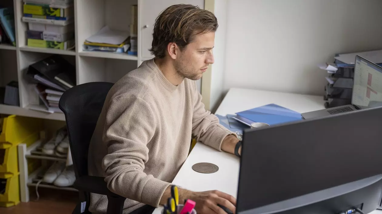 Bărbat surprins în timp ce lucrează la laptop