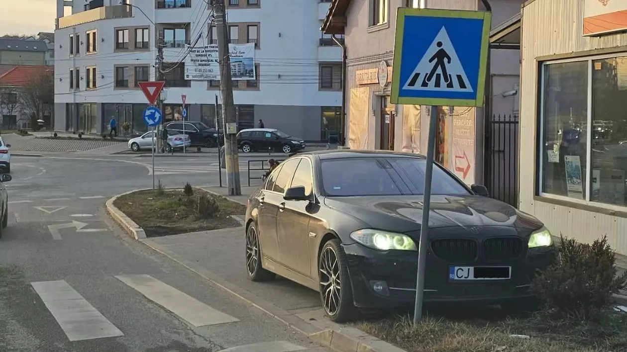 Poză cu BMW-ul parcat pe spațiul verde, în Cluj-Napoca.