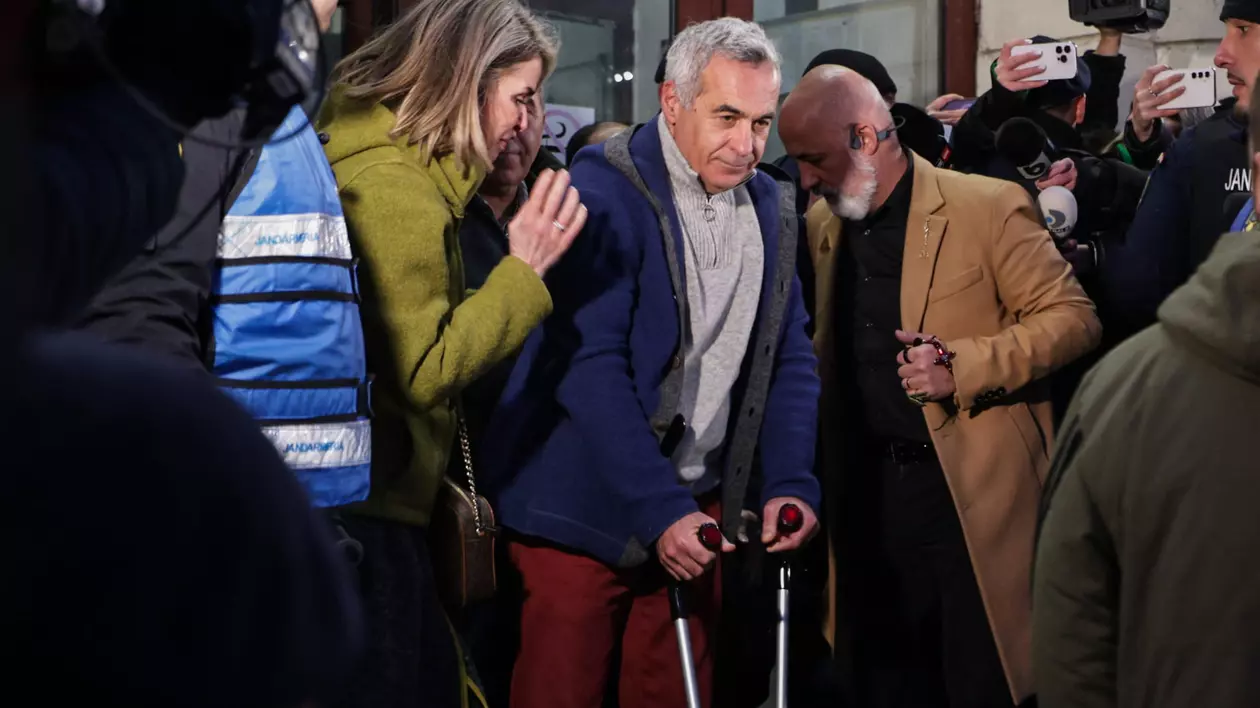 Călin Georgescu în cârje pe treptele de la Parchetul General, cu Cristela Georgescu lângă el.