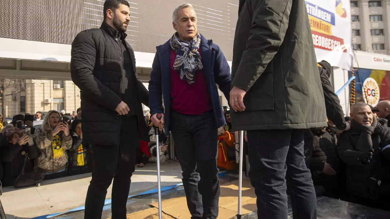 Calin Georgescu, merge cu cârje, flancat de doi bărbați, participa la un eveniment in cadrul caruia se strang semnaturi pentru candidatura sa la alegerile prezidentiale din mai 2025, in Piata Constitutiei din Bucuresti, sambata, 22 februarie 2025.