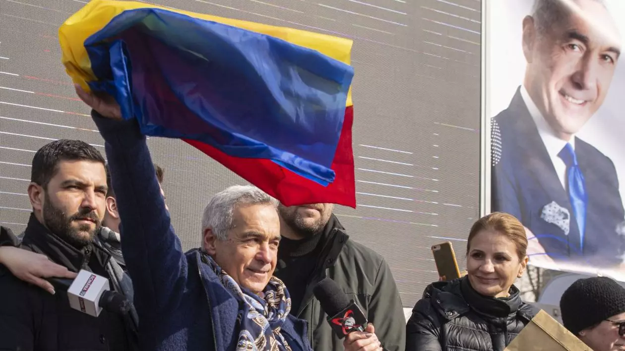 Calin Georgescu flutura un steag tricolor in timpul unui eveniment in cadrul caruia se strang semnaturi pentru candidatura sa la alegerile prezidentiale din mai 2025, in Piata Constitutiei din Bucuresti, sambata, 22 februarie 2025