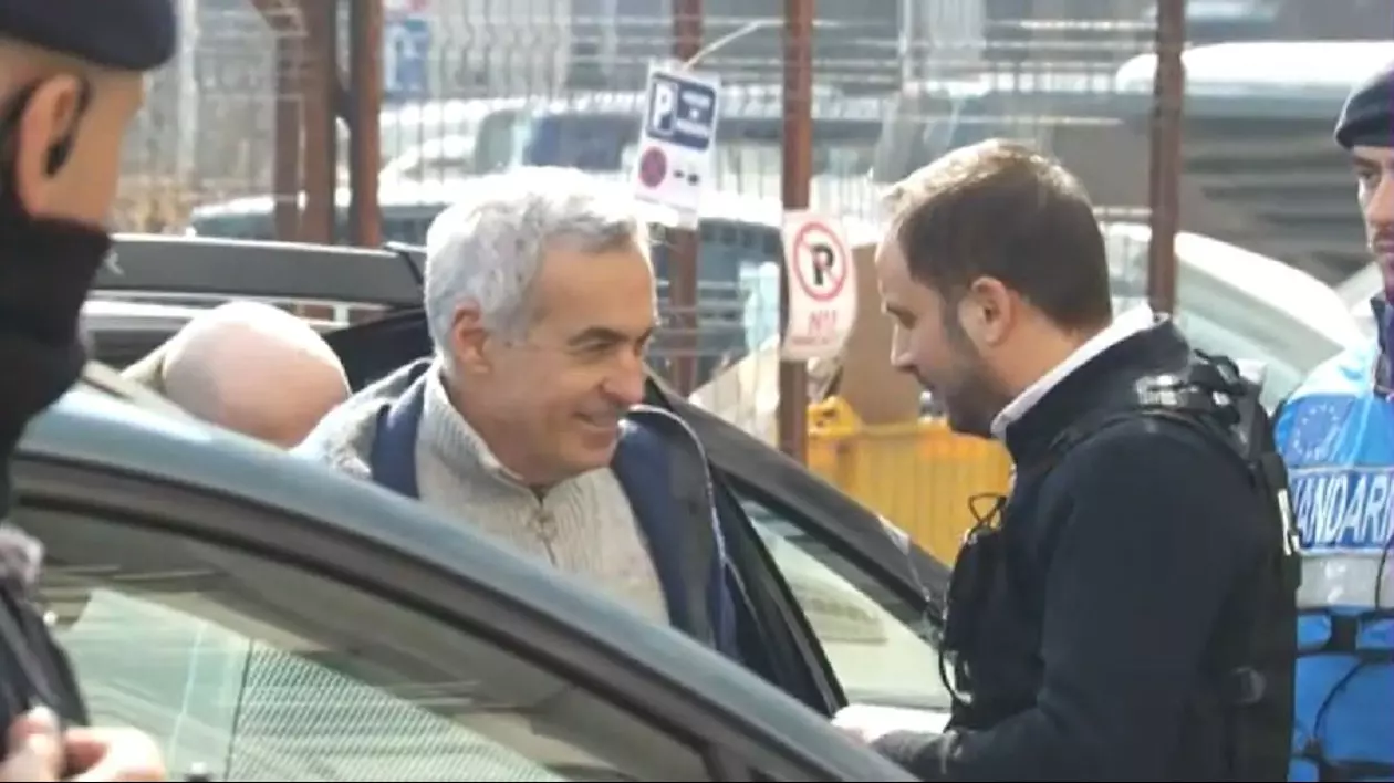 Călin Georgescu, zâmbind, după ce a coborât din mașina poliției, pentru a merge la audieri. Captură video Digi 24