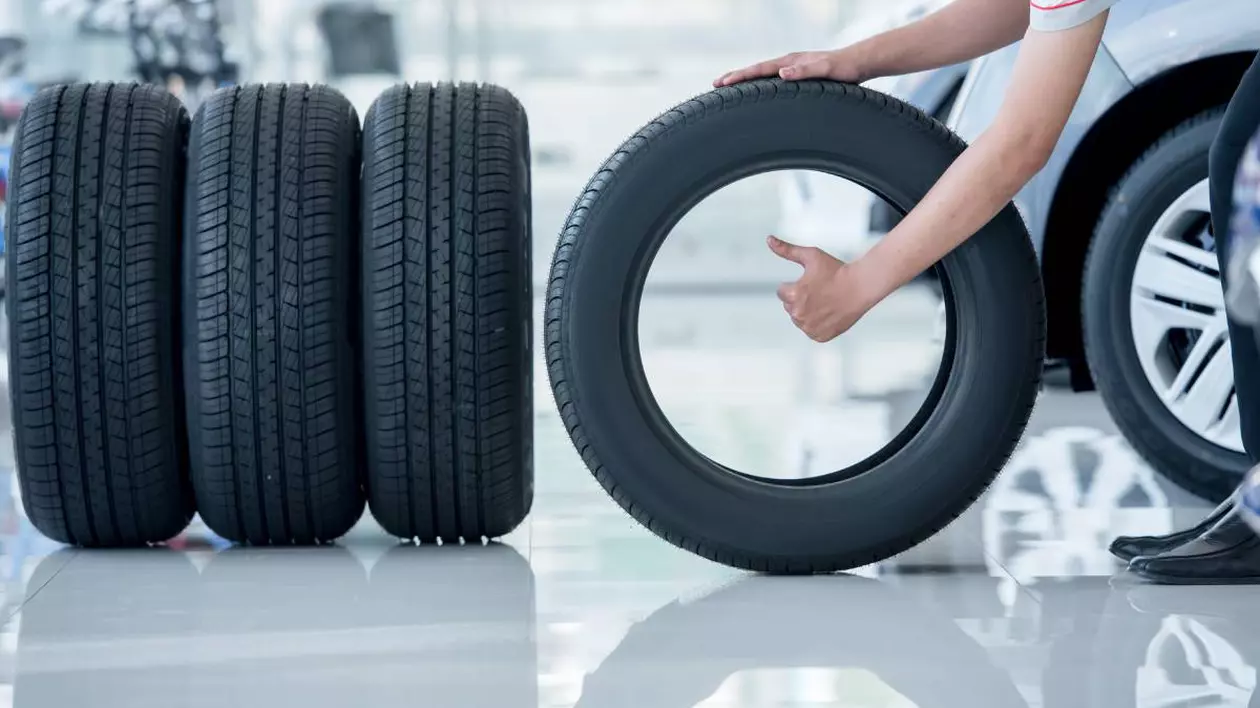 cauciucuri auto prezentate intr-un showroom, in partea dreapta se observa mana unui mecani care indica semnul ok