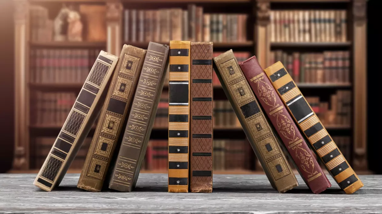 Ce este Ediția Princeps - Imagine cu cărţi vechi, frumos legate, aşezate pe o masă de lemn, având în fundal o bibliotecă