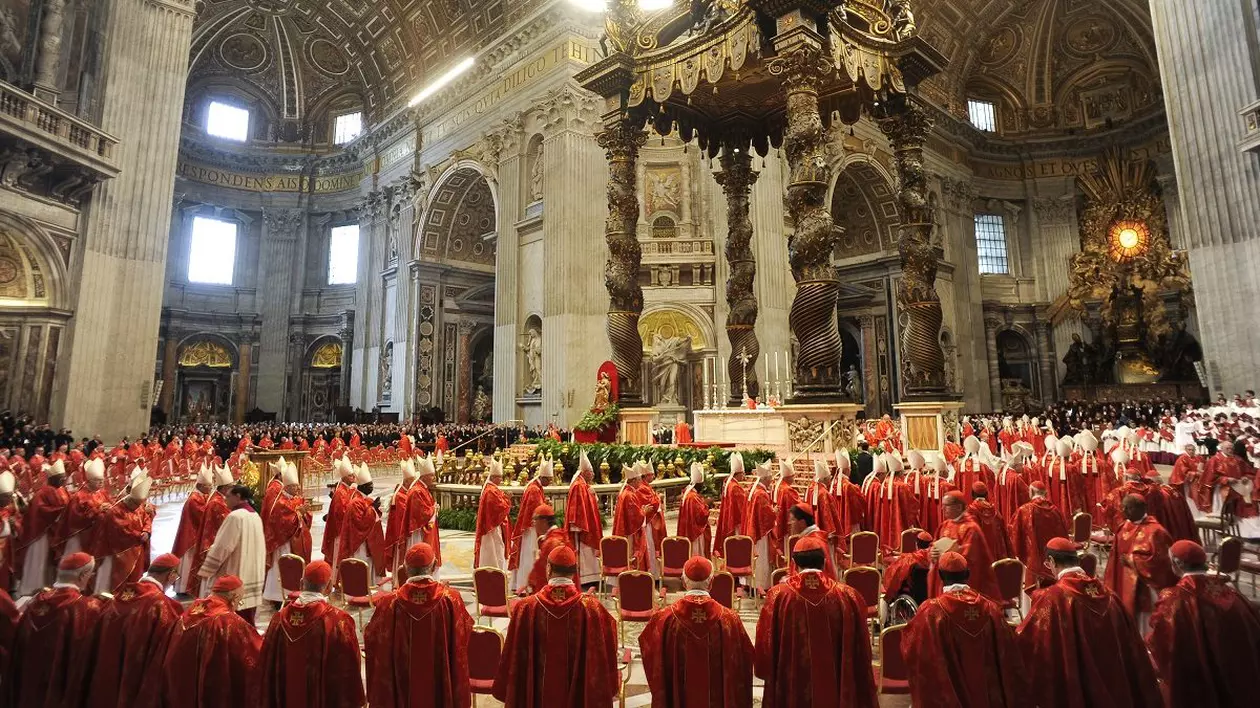 Zeci de cardinali îmbrăcați în roșu și alți clerici, ântr-o biserică, la Roma.