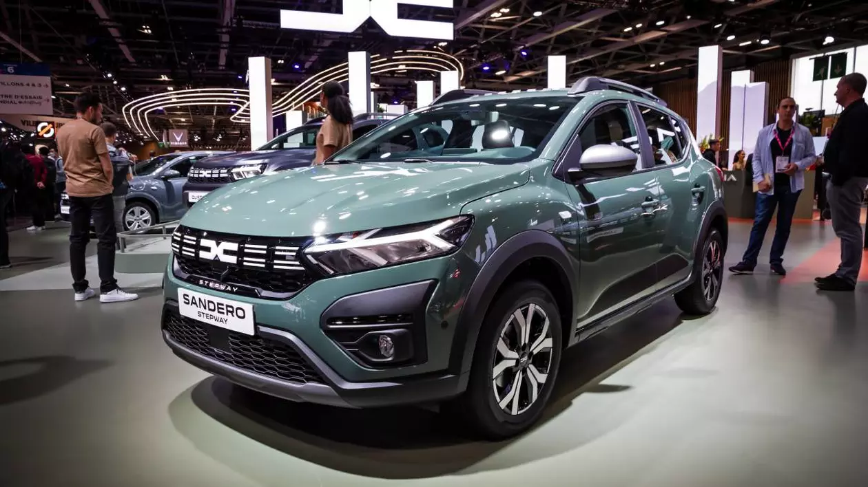 dacia sandero intr-un showroom, in jurul masinii sunt mai multi oameni care studiaza modelul