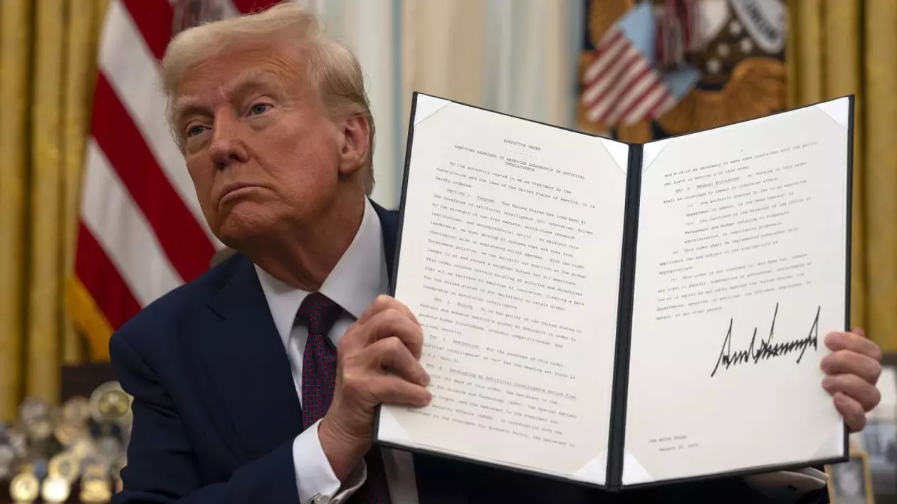 Donald Trump, în Biroul Oval de la Casa Albă, în timp ce arată un ordin executiv semnat