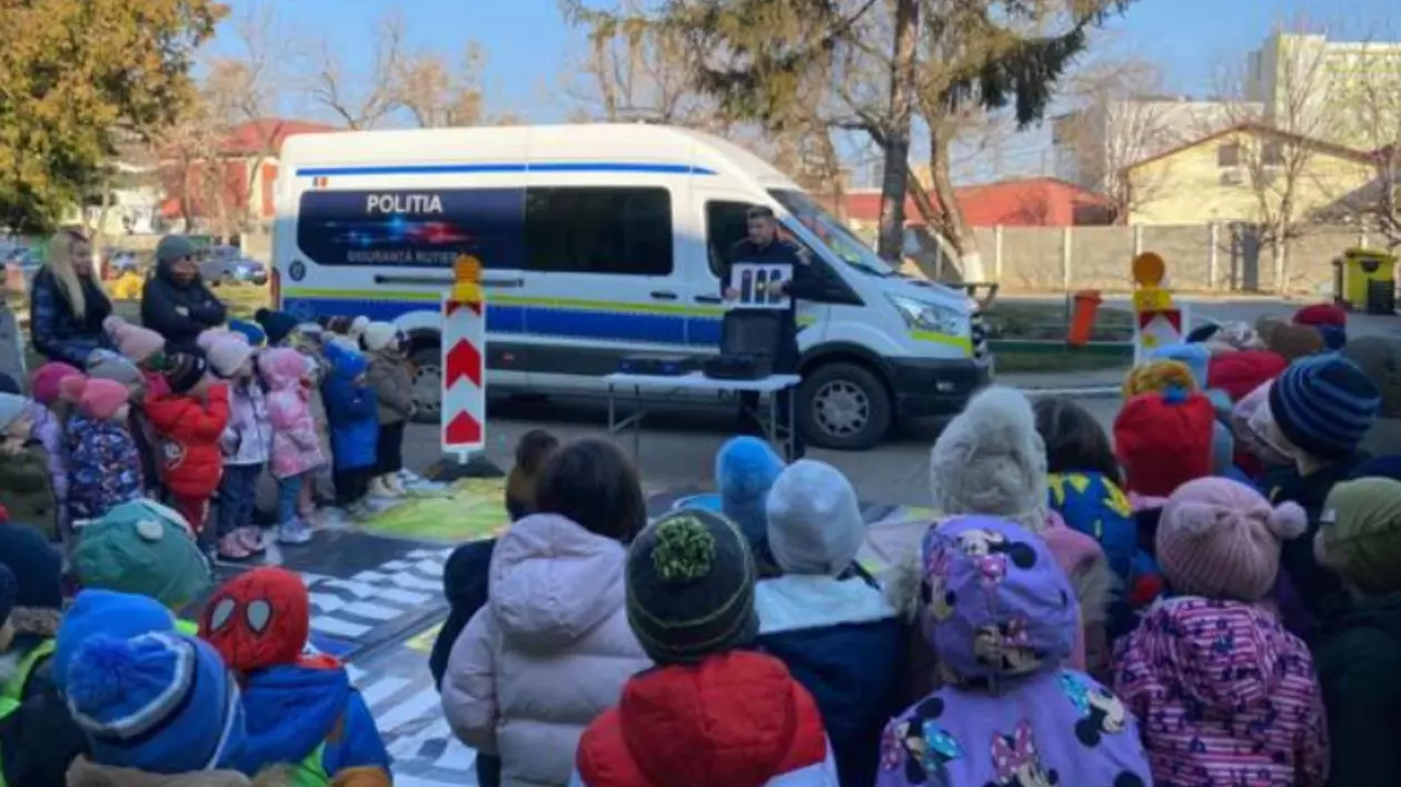 Un polițist care explică elevilor despre siguranța și comportamentul în trafic