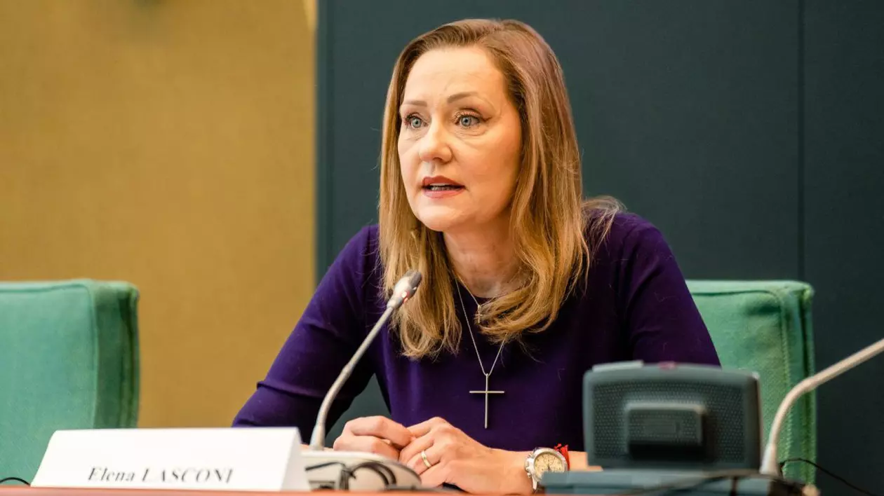 Elena Lasconi în spatele unei mese, vorbind la un microfon.