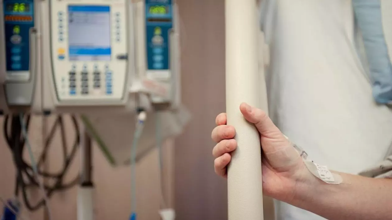 Femeie strângând patul de spital cu mâna