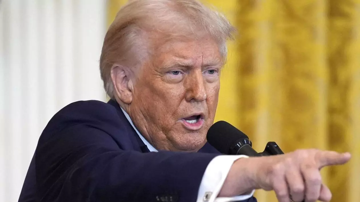 Donald Trump, arătând iritat cu degetul spre dreapta, îmbrpcat într-un sacou negru, cu manșeta cămășii albe la vedere