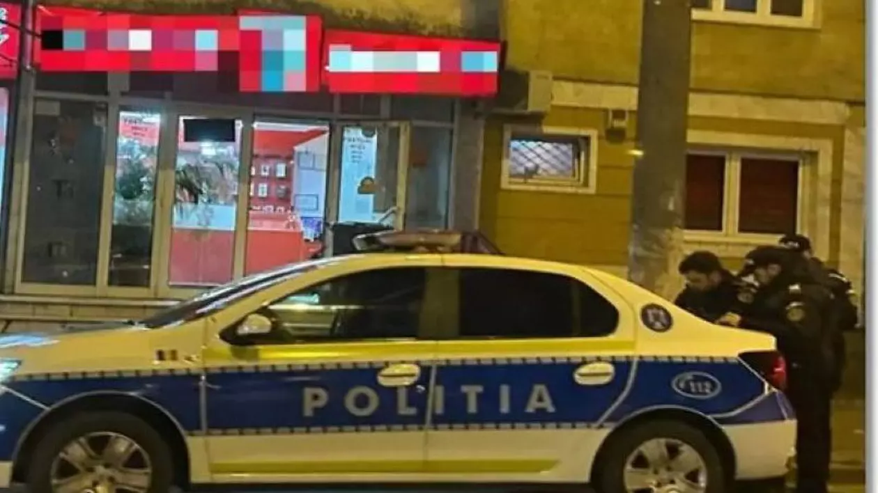 Agenții de poliție, alături de mașina de serviciu, la puțin timp după ce casa de amanet a fost jefuită