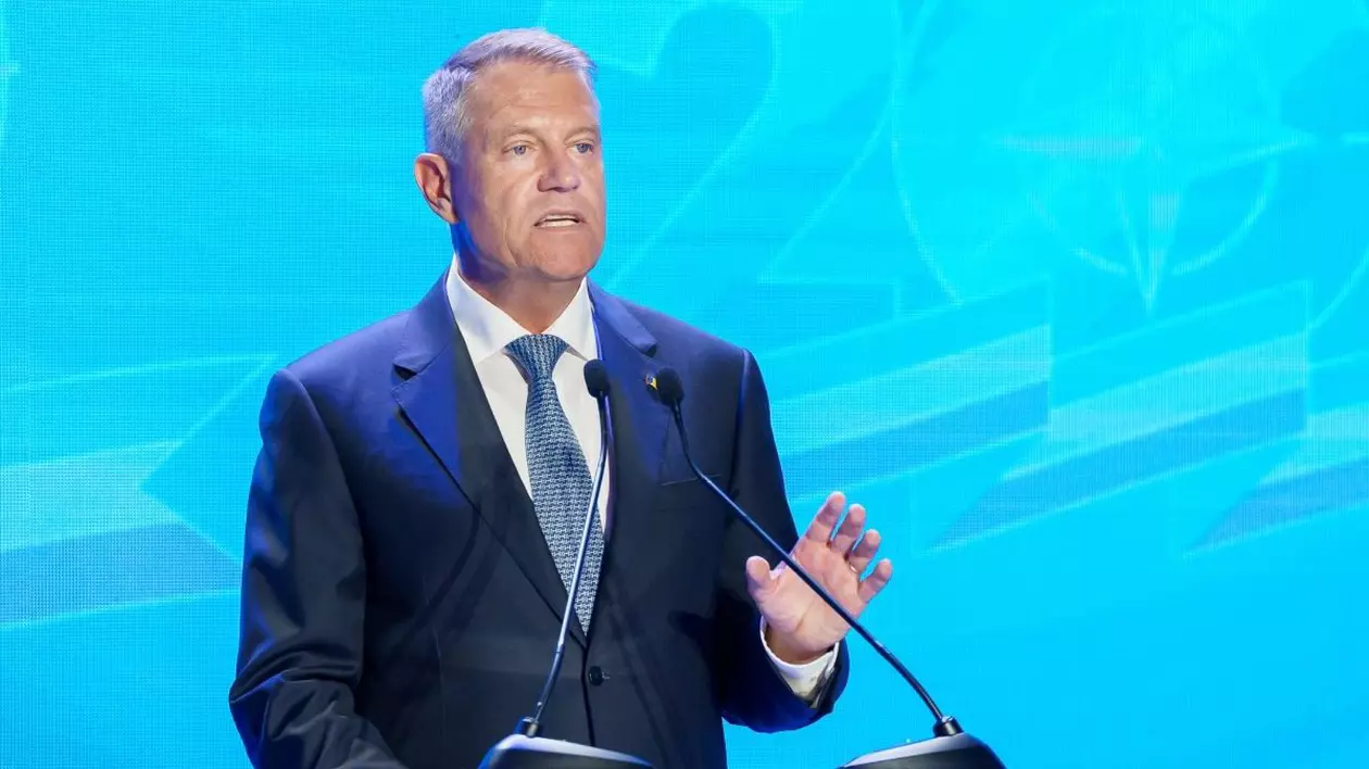 Președintele Klaus Iohannis vorbește la microfon, având în spate un fundal bleu