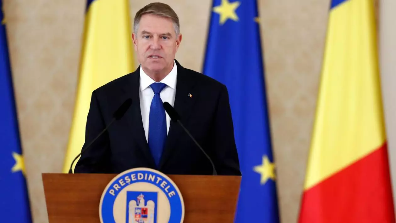 presedintele romaniei klaus iohannis in timpul unui discurs la pupitru, in spatele lui sunt drapelul romaniei si drapelul UE
