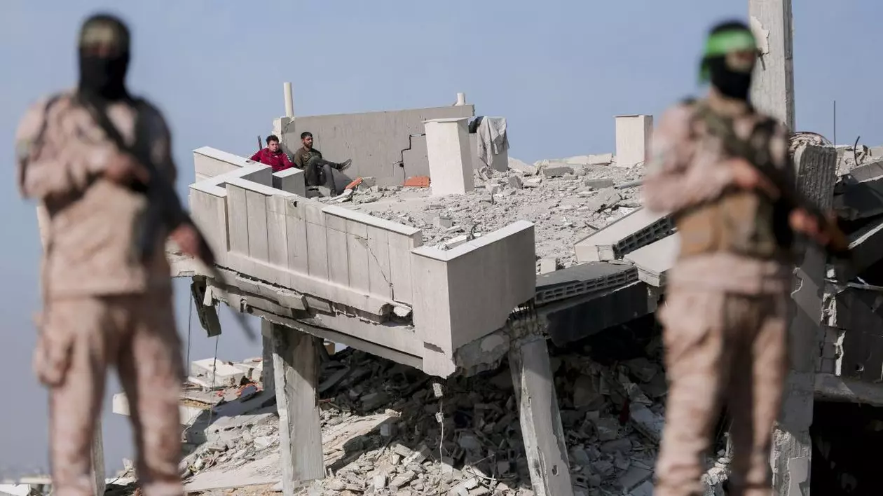 Luptătorii palestinieni Hamas stau de pază în Khan Yunis, Fâșia Gaza, pe 15 februarie 2025. Ei securizează zona ca parte a unui schimb de ostatici care implică eliberarea a trei ostatici israelieni în schimbul a 369 de prizonieri palestinieni