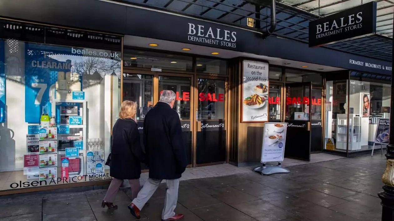 Doi oameni trec pe lângă magazinul Beales din Liverpool, pe 20 ianuarie 2020