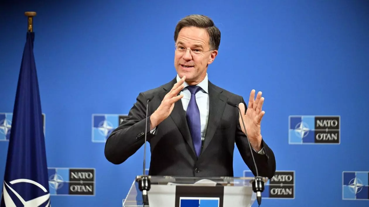 Mark Rutte, secretarul general al NATO, gesticulează din mâini. Este îmbrăcat cu costum și poartă cravată