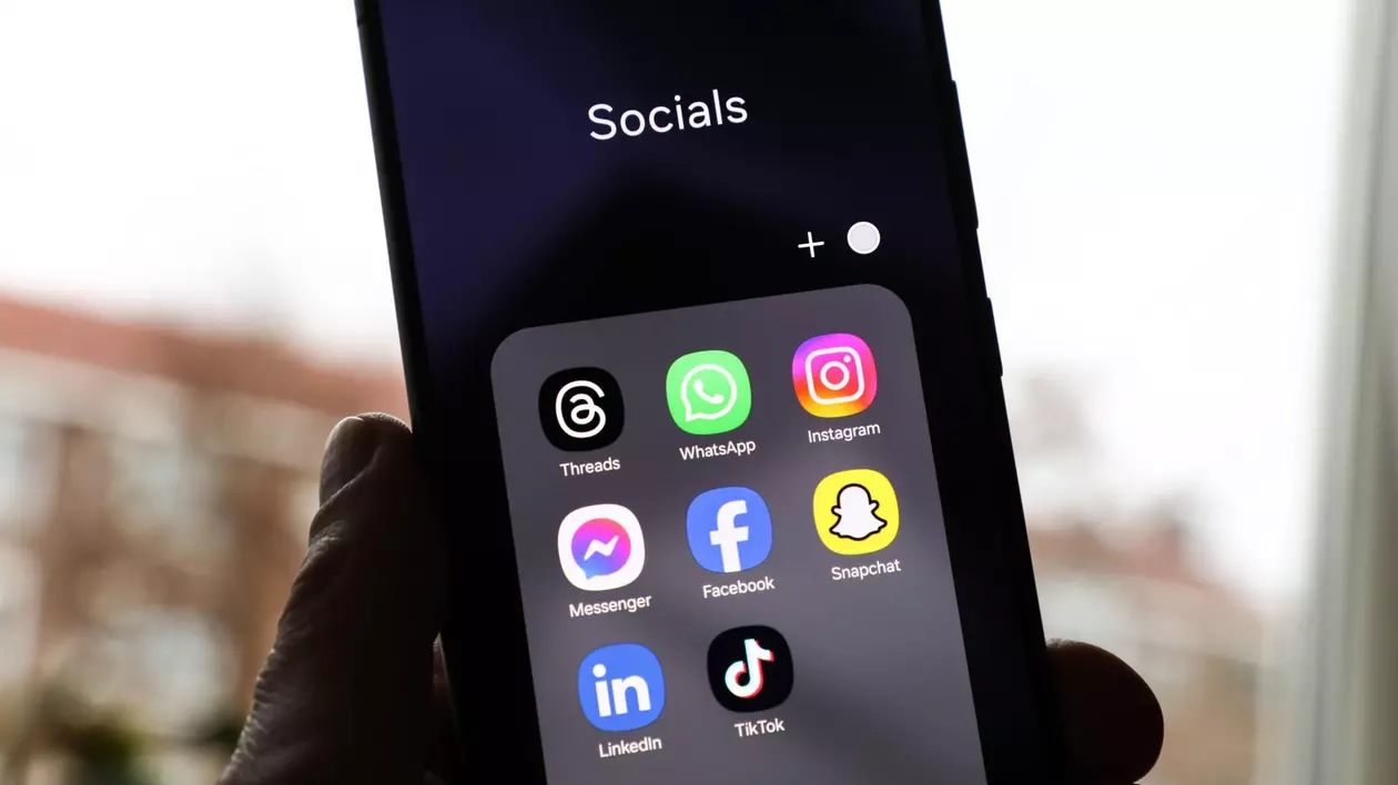 Un folder cu diverse aplicații de rețele sociale, deschis pe un telefon.